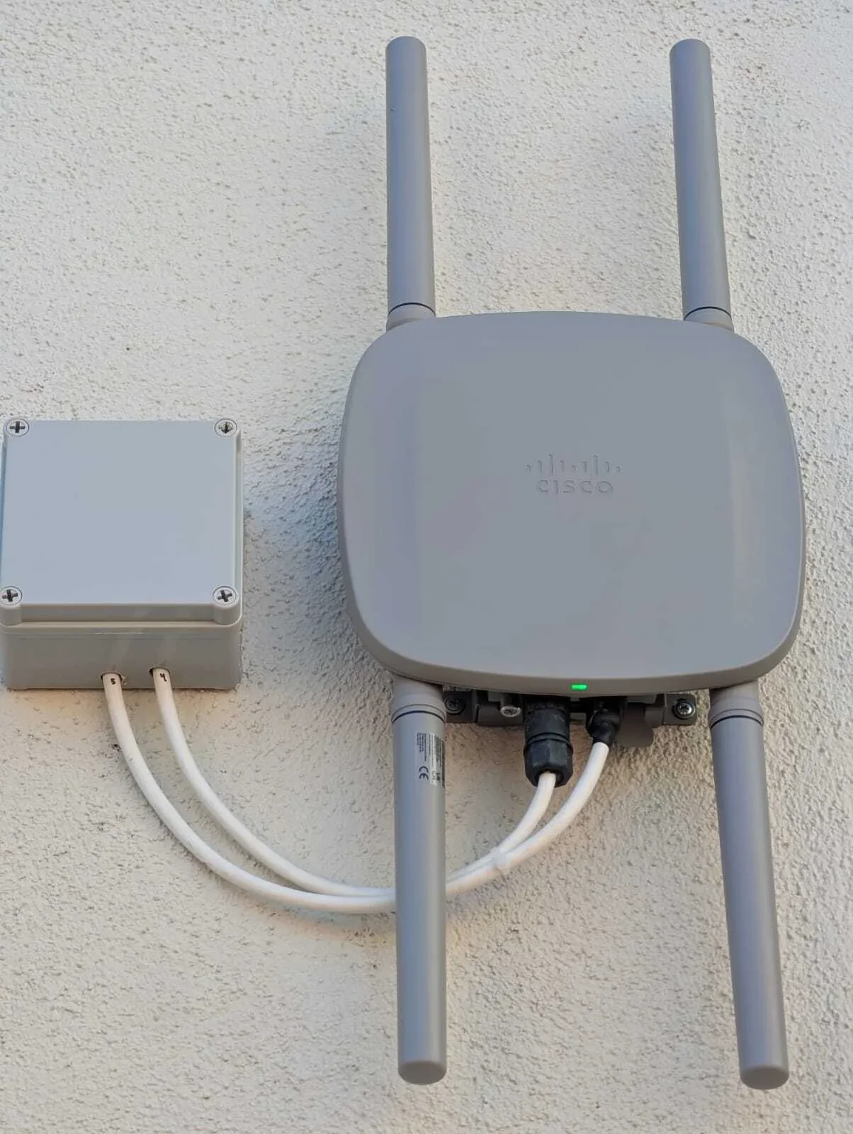 Cisco outdoor wireless access point with dual antennas mounted on exterior wall