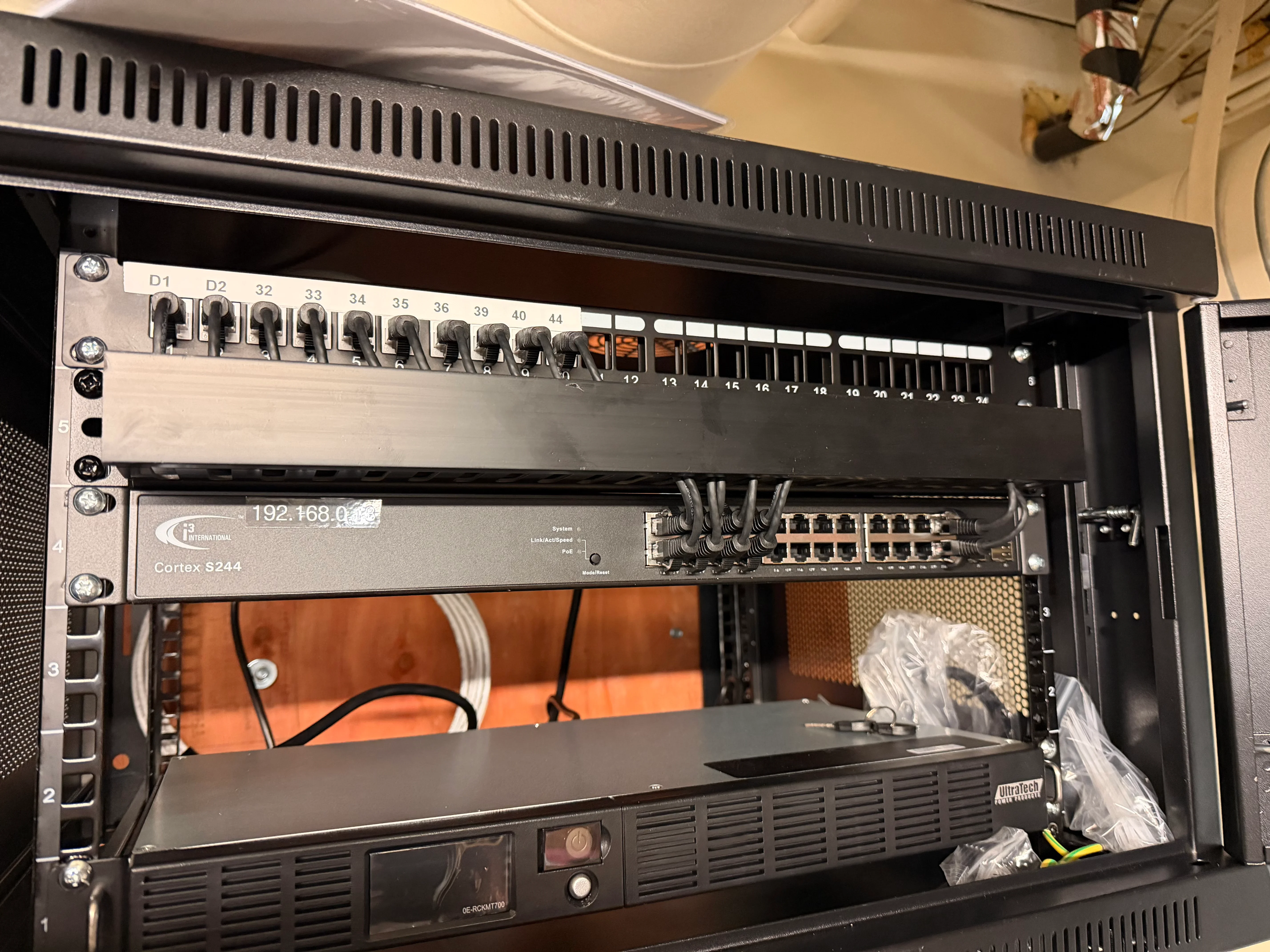 Cortex S244 network switch installed in black rack enclosure with organized cabling and numbered ports